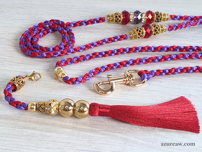 Laisse tressée rouge et violet avec perles, finitions dorées et pompon rouge amovible