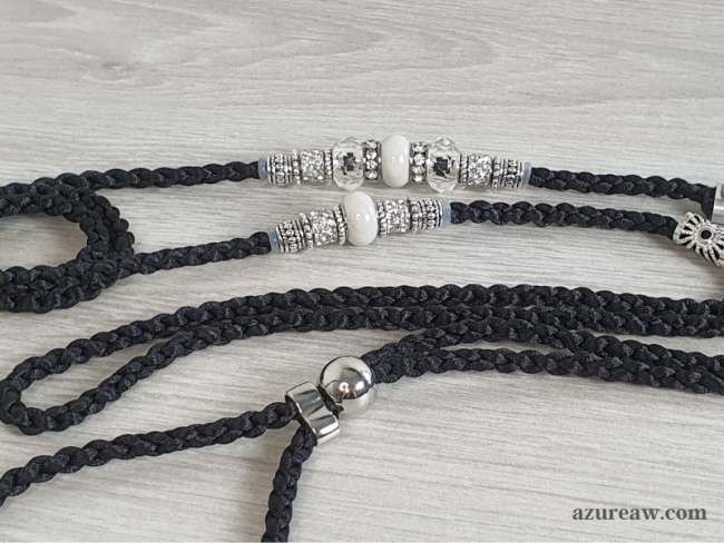 Laisse d’exposition tressée noire avec des perles transparentes, blanches nacrées et argentée Azureaw Laisse d’exposition Nocturne Élégante Azureaw, tressage noir avec perles transparentes, blanches nacrées et argentée.