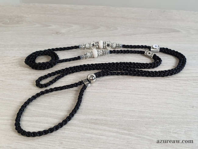 Laisse d’exposition tressée noire avec des perles transparentes, blanches nacrées et argentée Azureaw Laisse d’exposition Nocturne Élégante Azureaw, tressage noir avec perles transparentes, blanches nacrées et argentée.