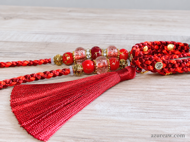 Laisse d’exposition canine Prestige Bordeaux Azureaw, rouge et bordeaux avec sous-gorge strass, perles et pompon assorti, entièrement tressée main.