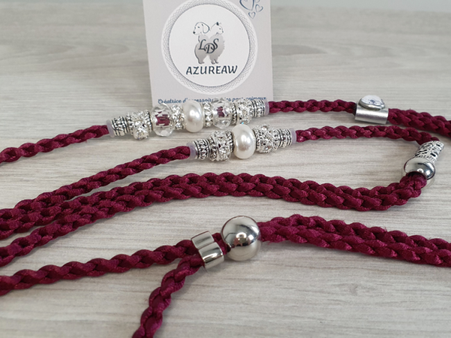 Laisse d’exposition tressée transparentes, blanches nacrées et argentée Azureaw Laisse d’exposition Lumière Prune Azureaw, tressage prune avec perles transparentes, blanches nacrées et argentée.