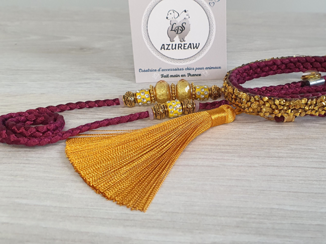 Laisse d’exposition Prune Lumière – Prune et finitions dorées Azureaw Laisse d’exposition prune Azureaw avec sous-gorge pailleté doré, perles et pompon dorés