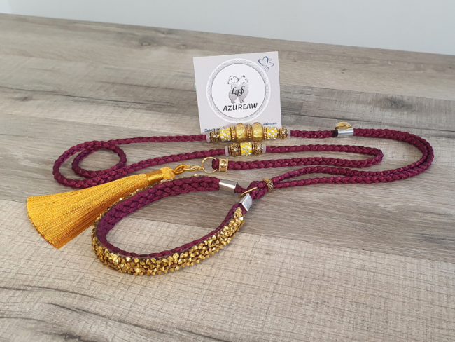 Laisse d’exposition Prune Lumière – Prune et finitions dorées Azureaw Laisse d’exposition prune Azureaw avec sous-gorge pailleté doré, perles et pompon dorés