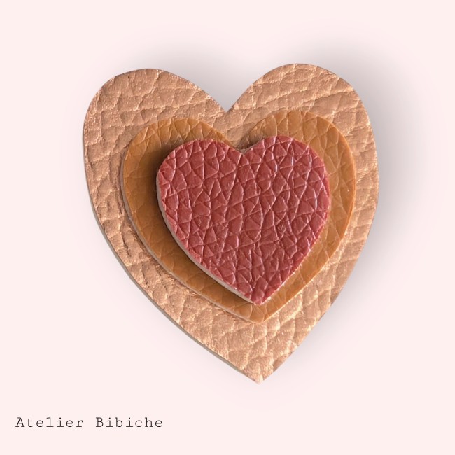 Broche cœur triple couche : extérieur cuivré métallisé, milieu brun caramel et cœur intérieur terracotta texturé.