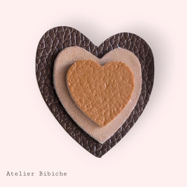 Broche cœur triple couche : extérieur brun foncé texturé, milieu beige poudré et cœur intérieur caramel.