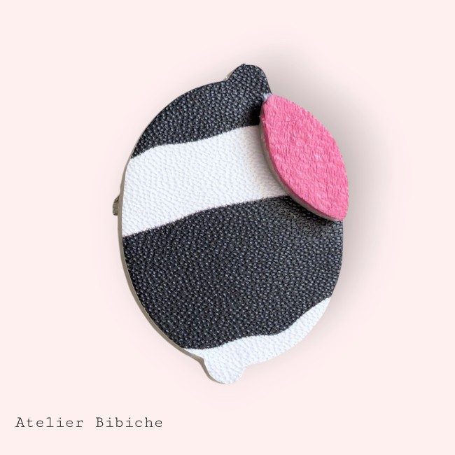 Broche en forme de citron stylisé, motif rayé noir et blanc avec une feuille en simili-cuir rose néon.