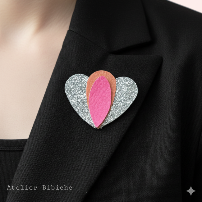 Broche Cœur Lotus Fait Main Argent Pailleté, Rose néon Broche en forme de cœur argenté pailleté avec un motif central en forme de pétale de lotus, orange corail et rose fuchsia.