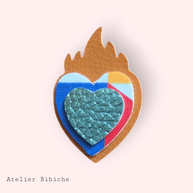 Broche Cœur Sacré Fait Main - Sacred Heart Style Mexicain Broche en forme de Cœur Sacré avec une flamme brun tanné. Cœurs intérieurs en simili-cuir bleu, rouge et turquoise texturé, dans un style géométrique pop.