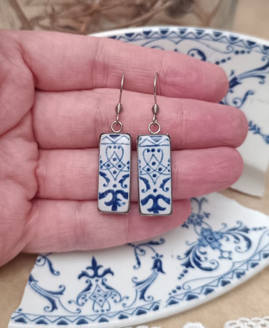 boucles-faience-ancienne--main Boucles en faïence ancienne présentées en main pour visualiser leurs supports rectangulaires de 10 × 30 mm.