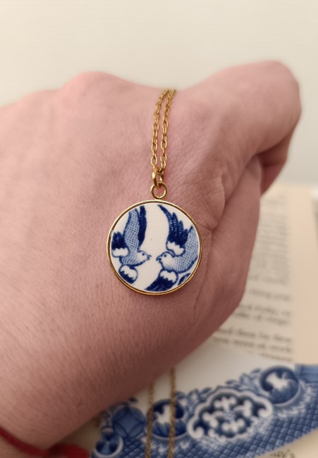 Collier présenté en main pour apprécier les dimensions du pendentif et les détails du motif Blue Willow.