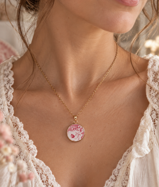 Collier porté avec pendentif en porcelaine vintage rouge grenadine et crème, monté sur support plaqué or 24 carats.
