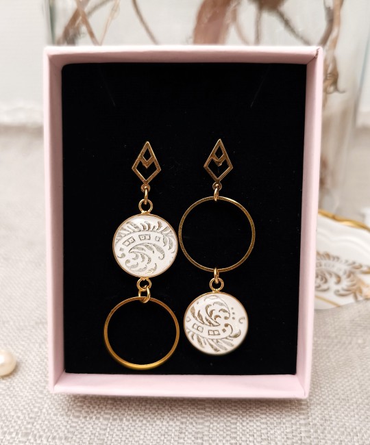 Boucles Célestes en faïence ancienne présentées dans leur écrin, pièce unique artisanale prête à offrir.
