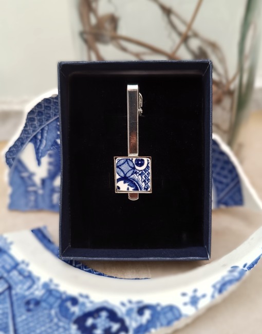 Pince à cravate en faïence ancienne présentée dans son écrin, cadeau unique pour homme à l'occasion des noces de faïence.