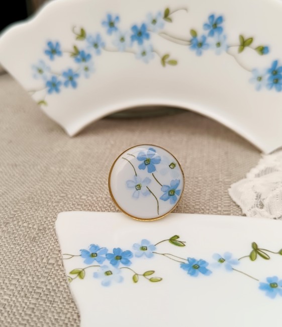 Bague Myosotis en Arcopal 22 mm plaqué or 24 carats, bijou artisanal réglable en verre opalin aux fleurs bleues.