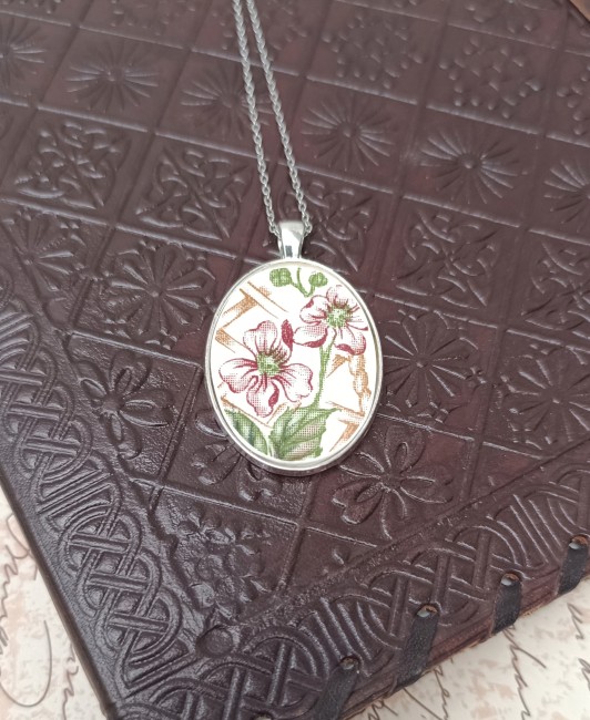 Collier jardin d'hiver posé sur un fond uni, bijou artisanal français en porcelaine upcyclée et unique.