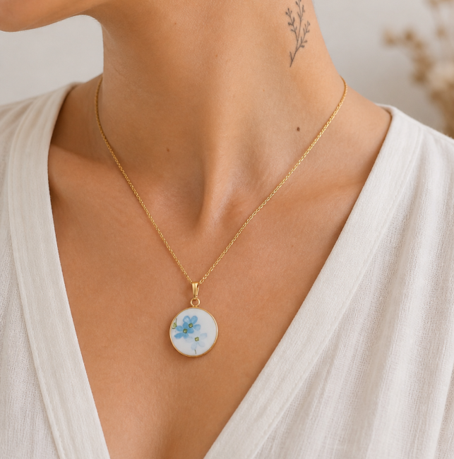 Collier Myosotis porté, bijou en assiette recyclée aux fleurs bleues.