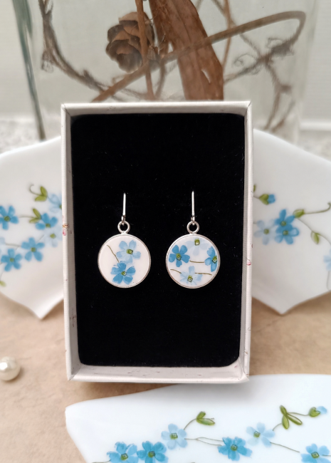 Boucles Myosotis en assiette recyclée présentées dans leur écrin.