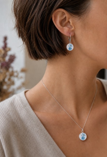 Boucles Myosotis portées, bijou en assiette recyclée aux fleurs bleues.