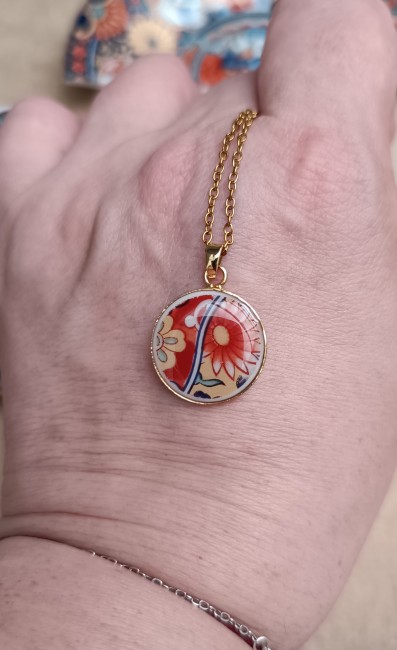 collier-imari-pendentif-18mm-main Collier Imari présenté en main pour visualiser le pendentif de 18 mm créé dans une ancienne théière en porcelaine japonaise.
