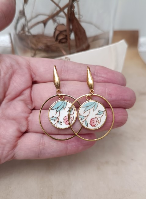 Boucles SAKURA tenues à la main, montrant le détail du motif floral japonais sur faïence ancienne Société Maastricht.