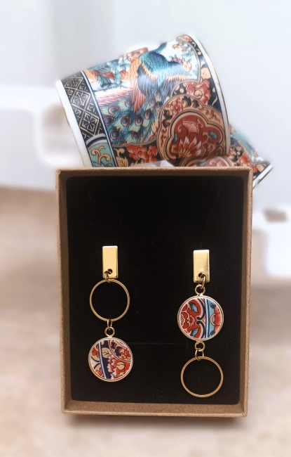 Présentation des boucles IRAMI dans leur boîte kraft recyclée, bijou unique en porcelaine ancienne, création française et éco-responsable.