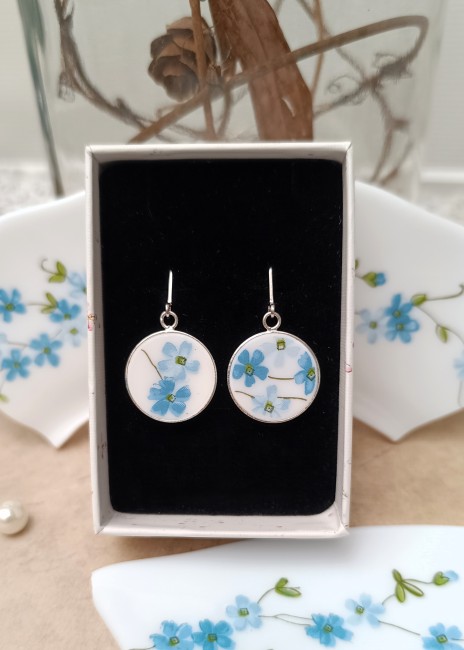Boucles Myosotis en assiette recyclée présentées dans leur écrin.