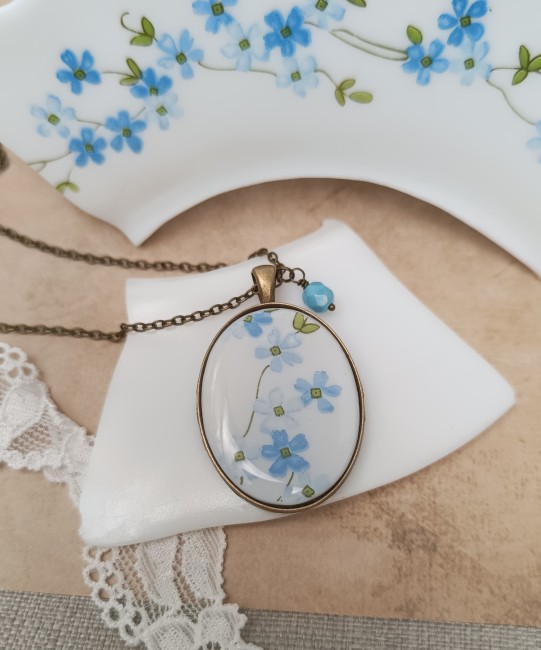 collier-myosotis-ovale-angle Collier Myosotis ovale en assiette Arcopal recyclée, fleurs bleues.
