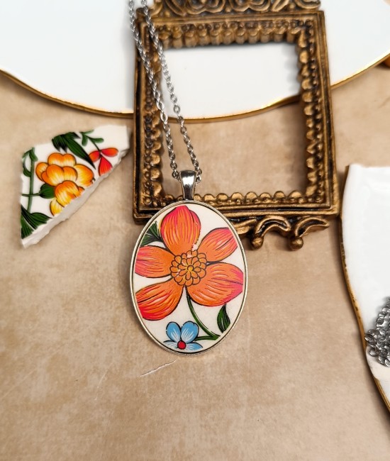 collier-samba-gien-fond-blanc Pendentif ovale Samba argenté en faïence ancienne de Gien, création artisanale française.