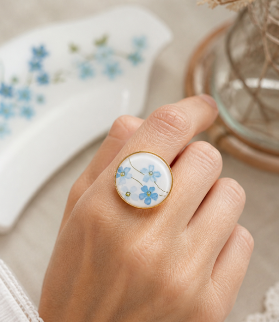 Bague Myosotis portée, bijou grand format lumineux et moderne en verre opalin.