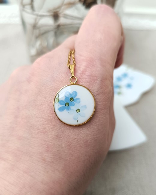 Détail du collier Myosotis, assiette Arcopal transformée en bijou fleuri.
