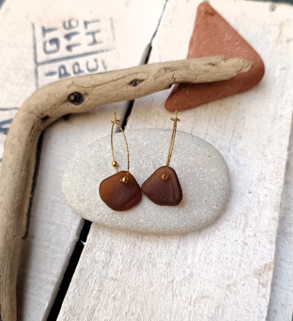 Détail des fragments de verre de mer et du montage en acier inoxydable doré.