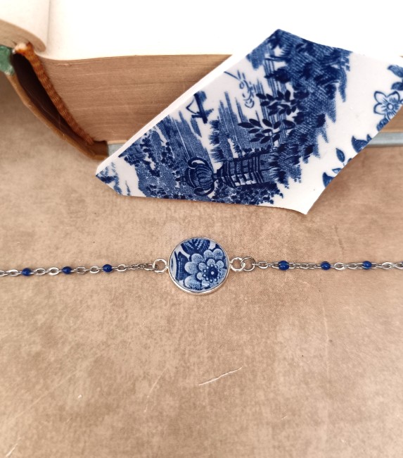 Bracelet en porcelaine anglaise Wood & Sons Woodland recyclée sur fond clair, support plaqué argent et chaîne émaillée bleue.