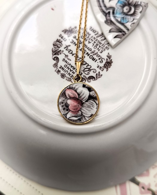 collier-divine-main-pendentif-rond-fond-clair Collier goutte Divine, bijou en porcelaine anglaise Ridgway Clifton, rose bordeaux, vue de face.