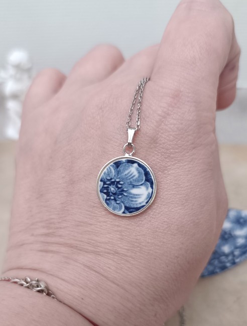 Détail d’un pendentif en porcelaine ancienne avec patine et microfissures. Chaque pièce est unique, façonnée à la main dans une démarche durable.