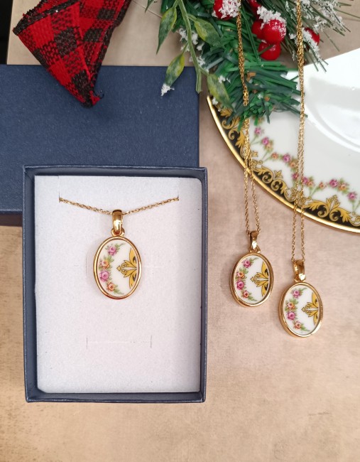 Colliers héritage familial – Porcelaine transformée – Présentation en écrin Présentation des trois colliers artisanaux créés à partir d’une assiette familiale en porcelaine. Bijoux ovales en étain plaqué or, fabrication française, présentés dans leur écrin.