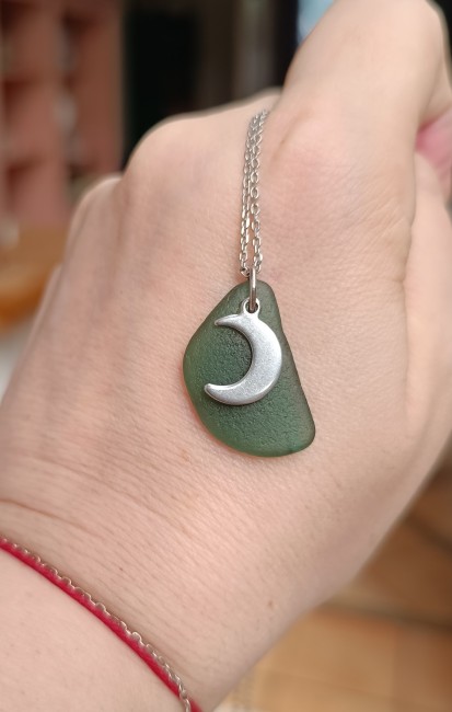 Gros plan sur le pendentif Moonlight : un fragment rare de verre de mer bleu, poli par l’océan et monté en collier artisanal français.