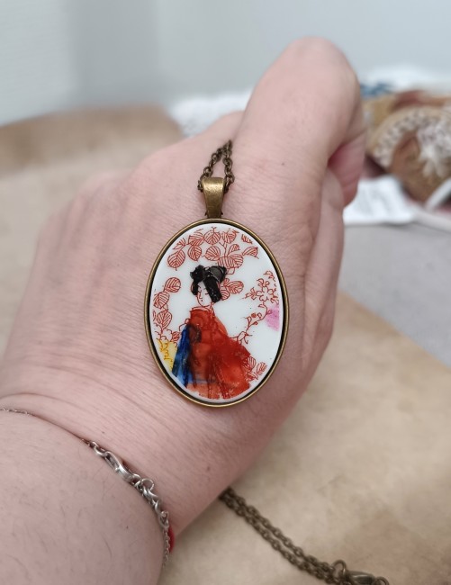 sautoir en porcelaine japonaise recyclée tenu à la main,  motif geisha