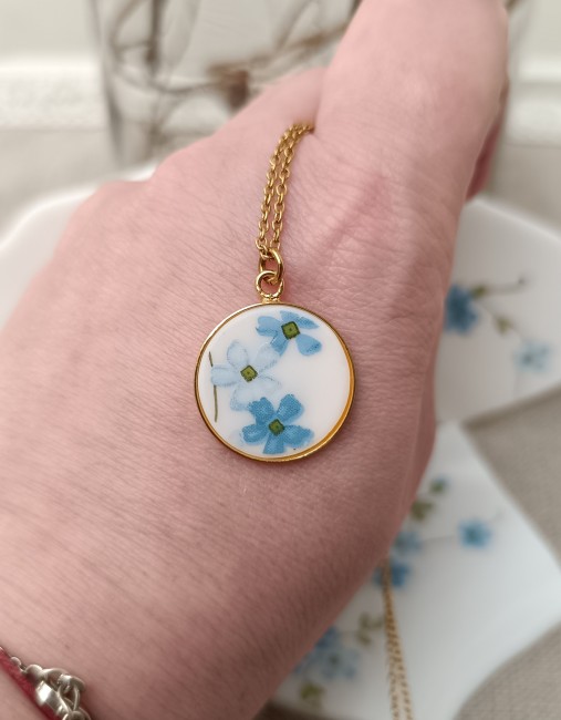 Détail du collier Myosotis, assiette Arcopal transformée en bijou fleuri.