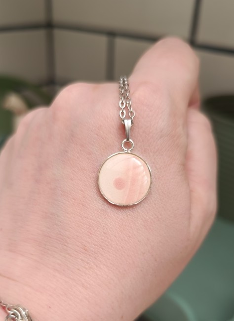 Collier présenté en main pour apprécier les dimensions et les détails du motif.