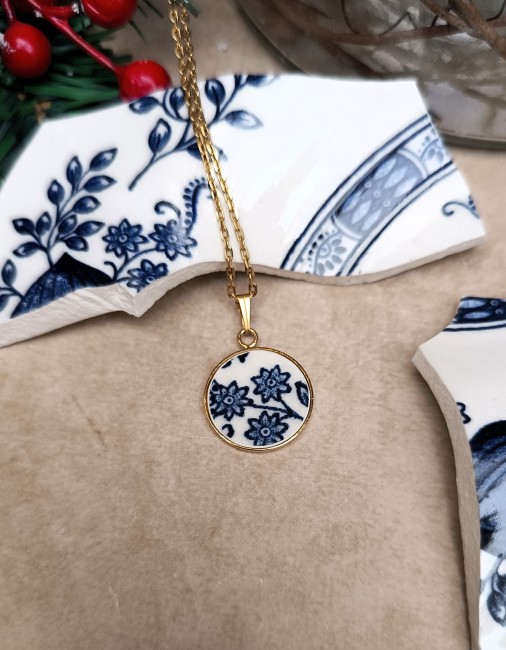 Collier Bleu Vintage en porcelaine anglaise – Vue posée Découvrez le collier Bleu Vintage, pièce unique en porcelaine anglaise ancienne, posé pour mettre en valeur son motif fleuri bleu sur fond blanc.