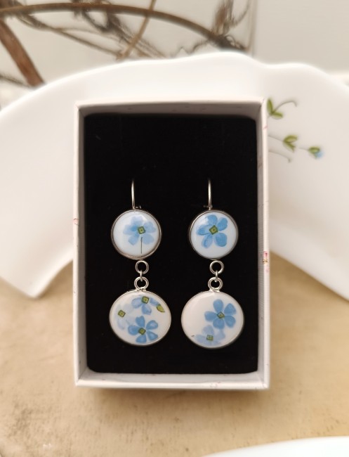 Boucles Myosotis double cabochon présentées dans leur écrin cadeau.