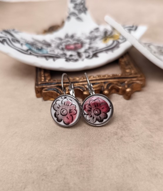 Détail du motif floral brun et rouge bordeaux sur fond blanc.