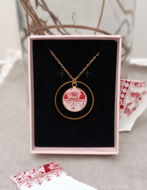 Bijoux personnalisés présentés en main pour visualiser les fragments de porcelaine de 18 mm issus de l’assiette familiale de la cliente.