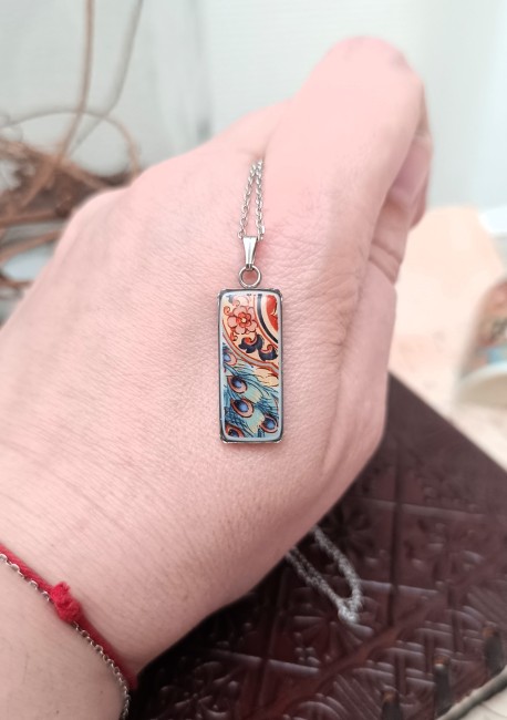 Collier Irami tenu dans la main, bijou unique en porcelaine ancienne, montrant la délicatesse des fragments de porcelaine japonaise ancienne transformés en bijou contemporain.
