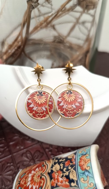 Boucles IRAMI posées sur un fond clair, montrant la délicatesse des fragments de porcelaine japonaise ancienne transformés en bijou contemporain.