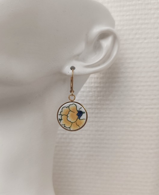boucles-oreilles-oeillet-jaune-portees Boucles d’oreilles Œillet Jaune portées, bijou délicat en porcelaine ancienne upcyclée. Élégance vintage et artisanat français.