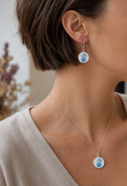Boucles Myosotis portées, bijou en assiette recyclée aux fleurs bleues.