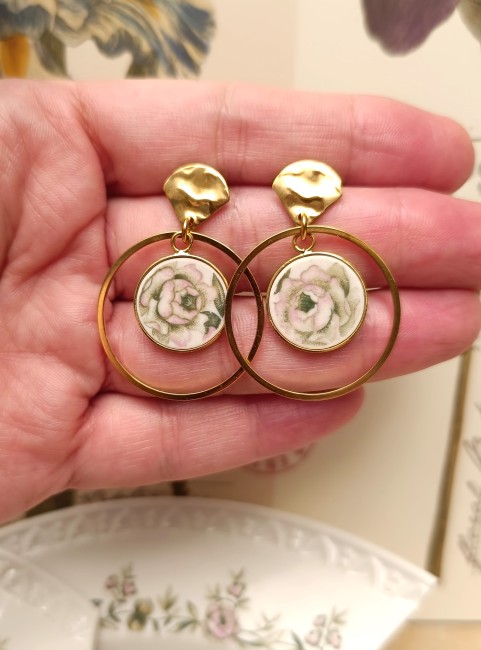 Gros plan sur les boucles d'oreilles Trianon mettant en valeur la finesse du décor floral inspiré du XVIIIᵉ siècle et la qualité des finitions.