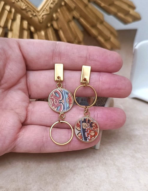 Boucles IRAMI tenues à la main, montrant la délicatesse des fragments de porcelaine japonaise ancienne transformés en bijou contemporain.