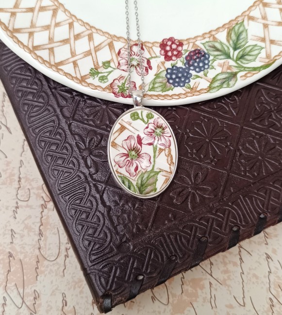 Collier jardin d'hiver posé sur un fond uni, bijou artisanal français en porcelaine upcyclée et unique.